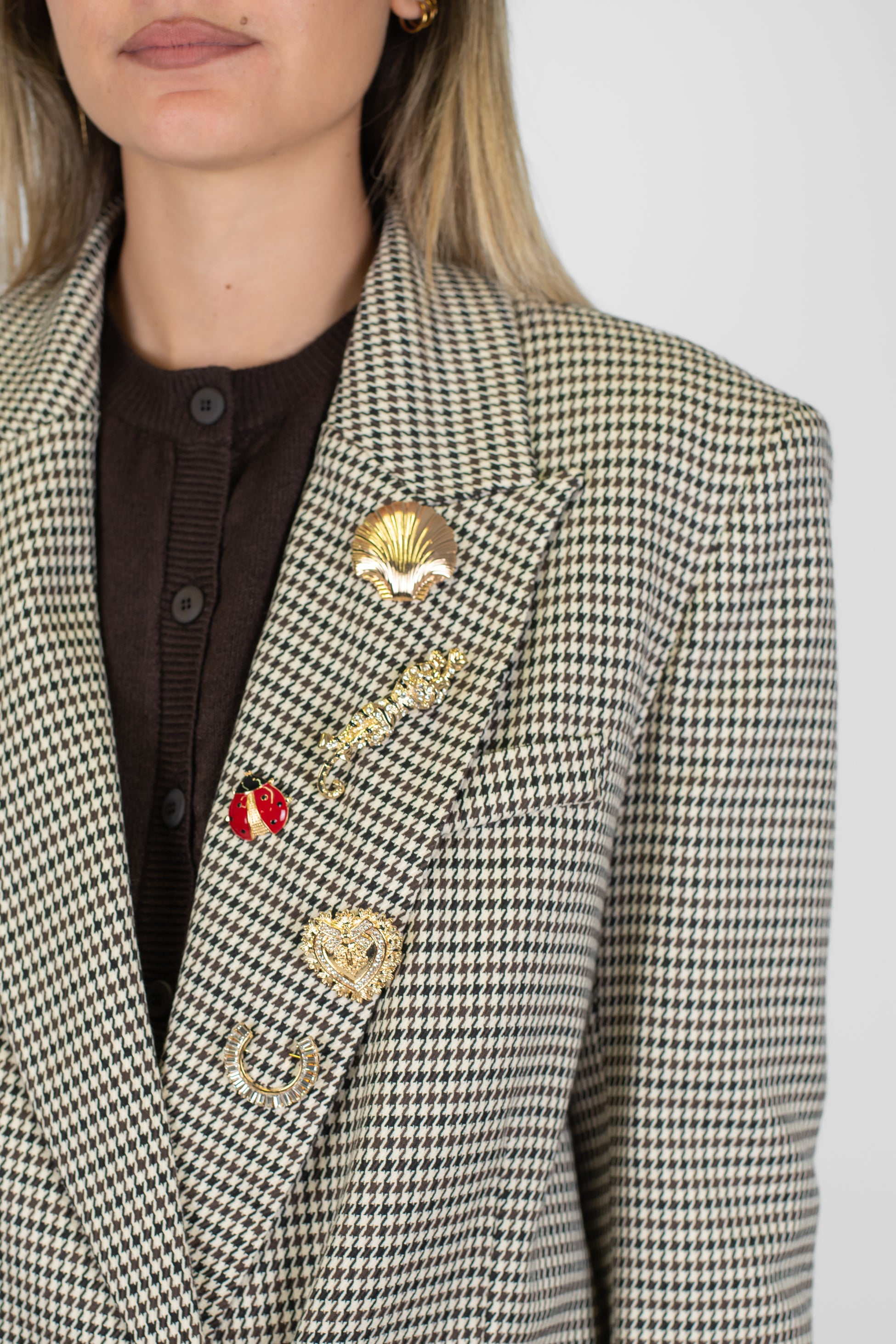 Tensione in - Giacca doppiopetto fantasia pied de poule con rever ampio a lancia e spille gioiello