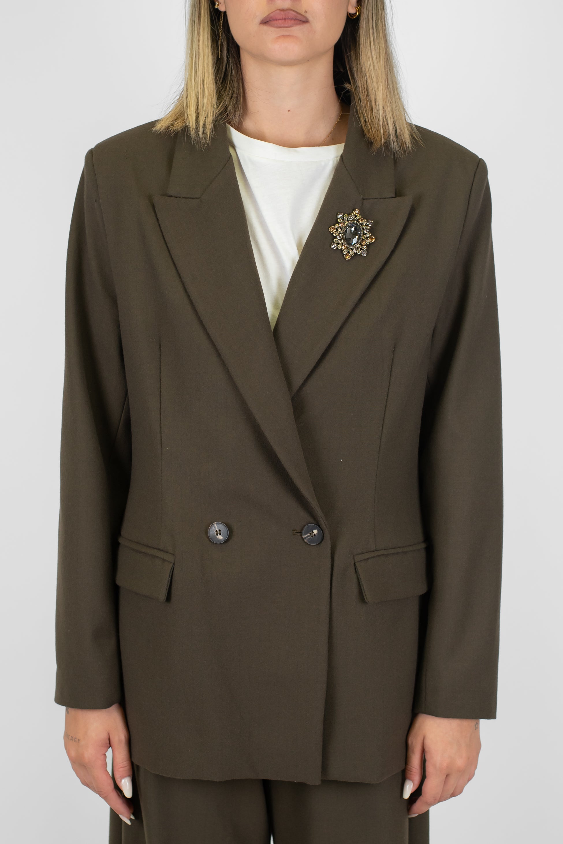 Tensione in - Giacca doppiopetto gessata con spilla gioiello