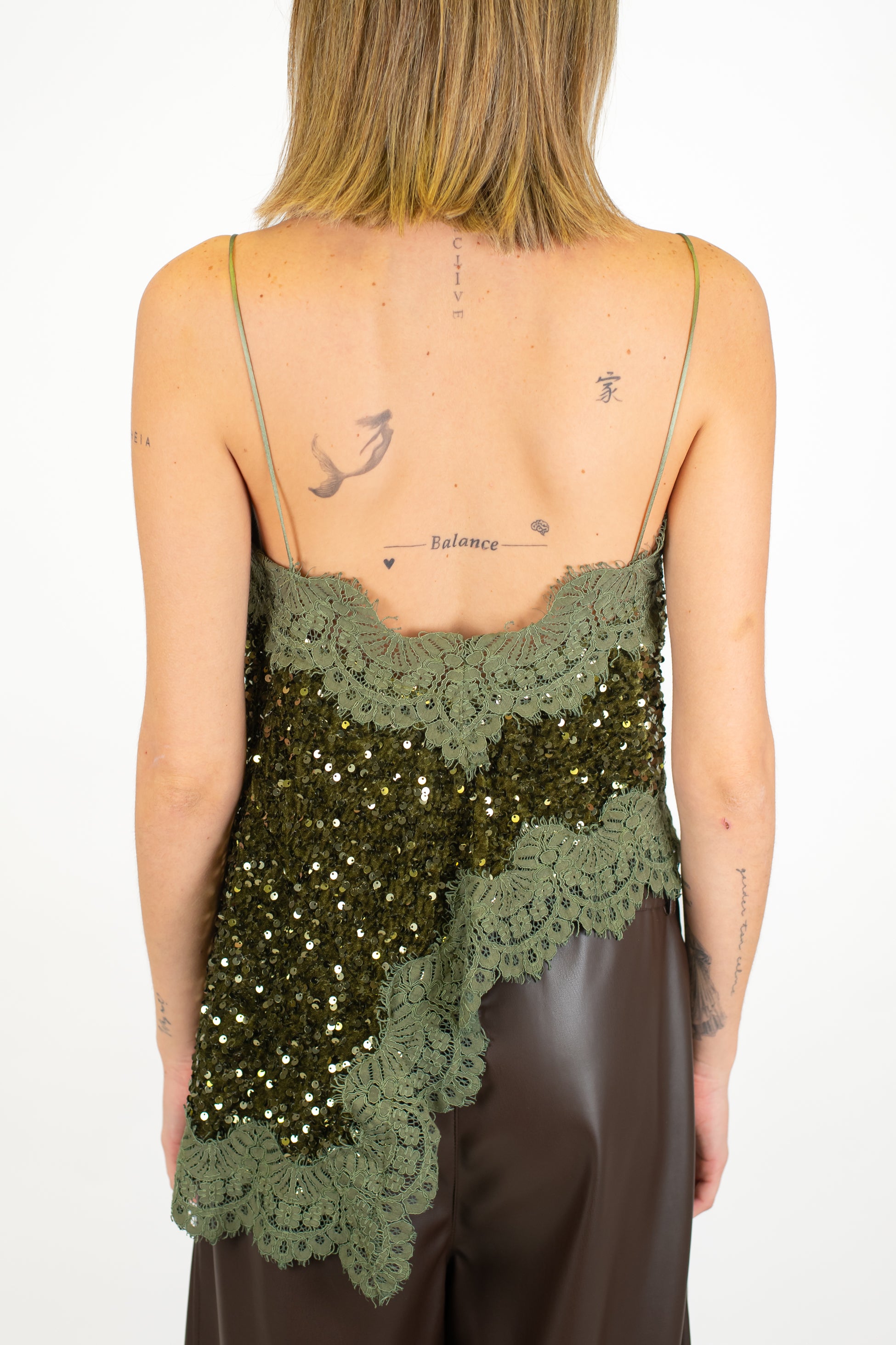 Tensione in - Top paillettes asimmetrico con orli in pizzo