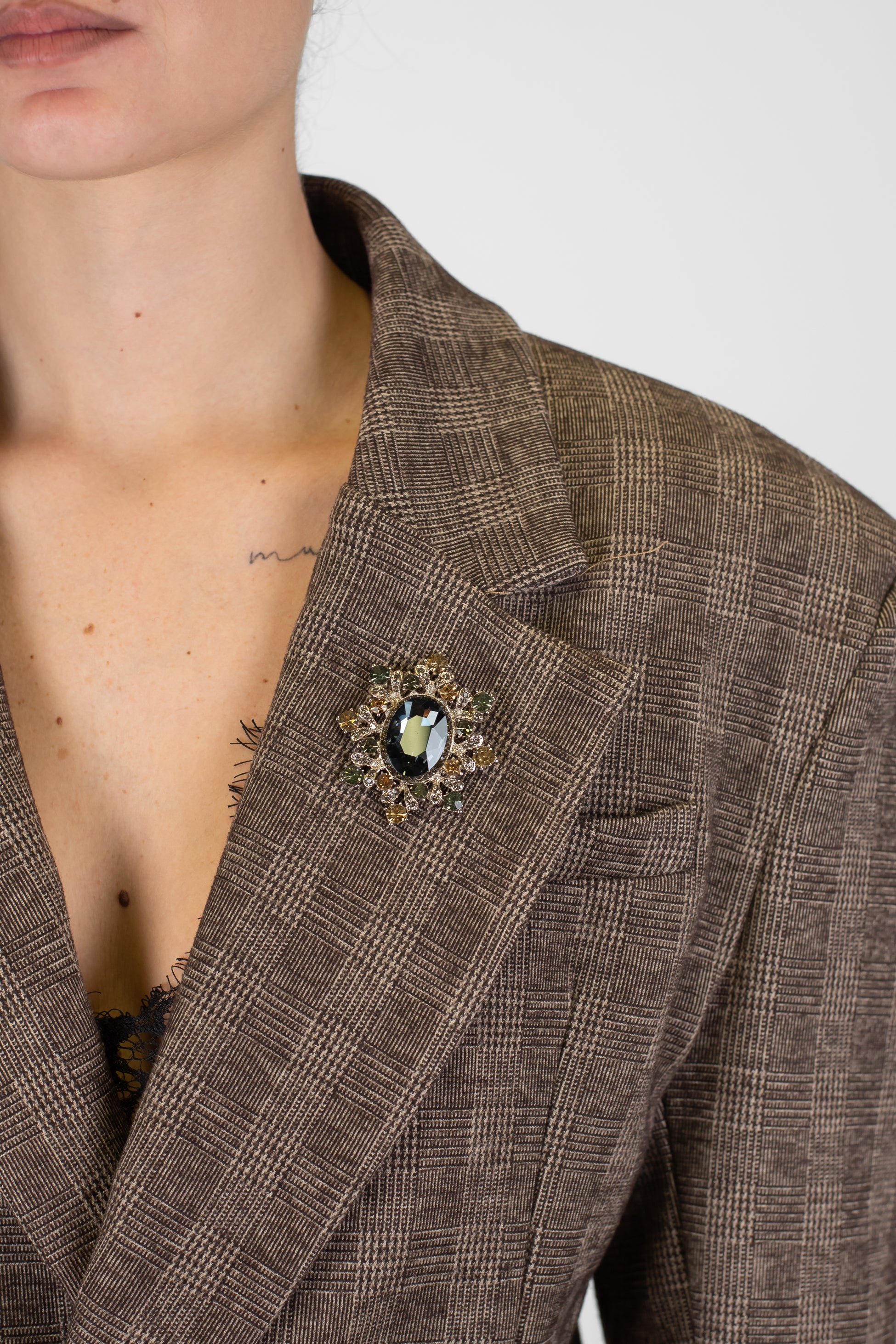 Tensione in - Giacca fantasia check avvitata con spalline e spilla