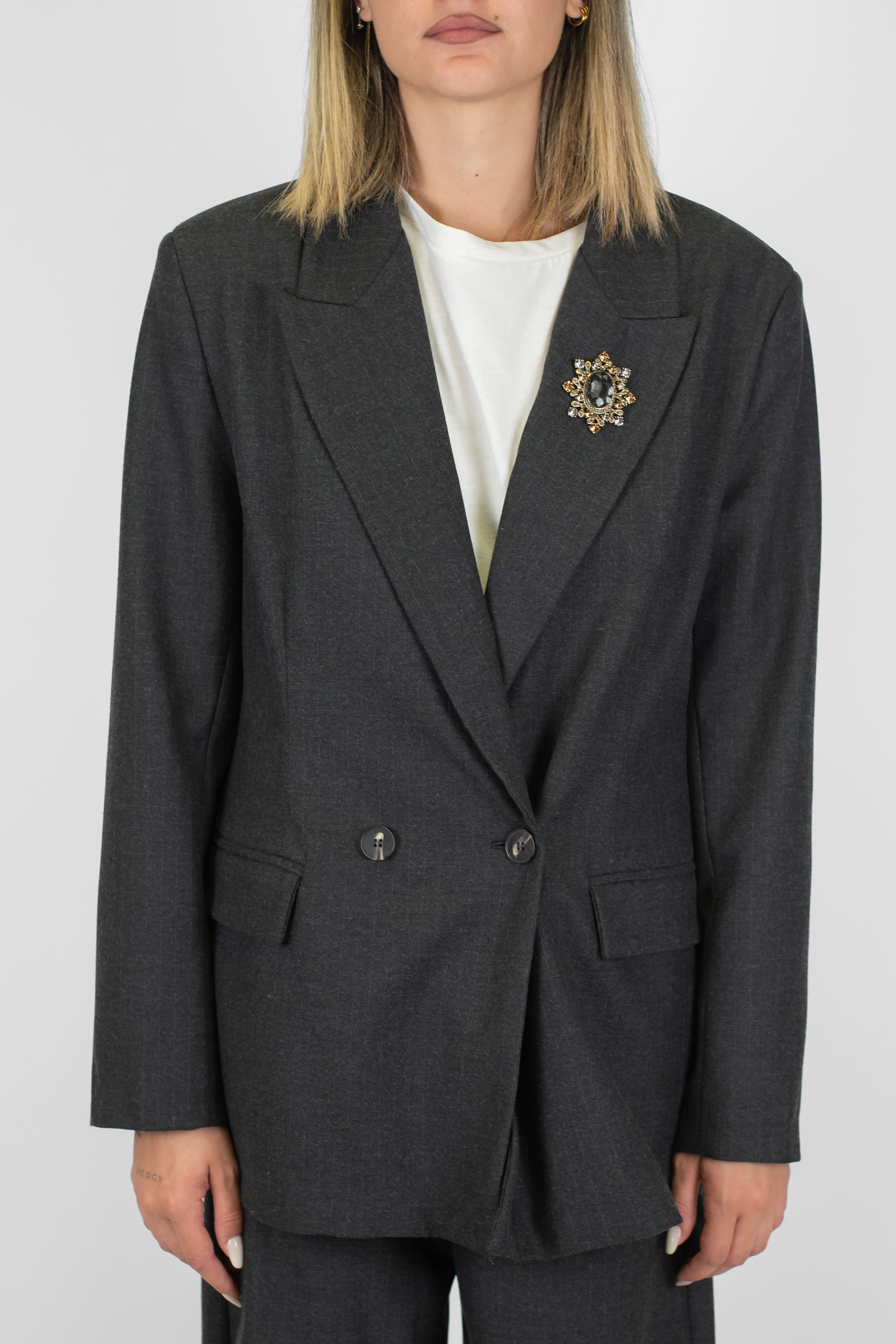 Tensione in - Giacca doppiopetto gessata con spilla gioiello