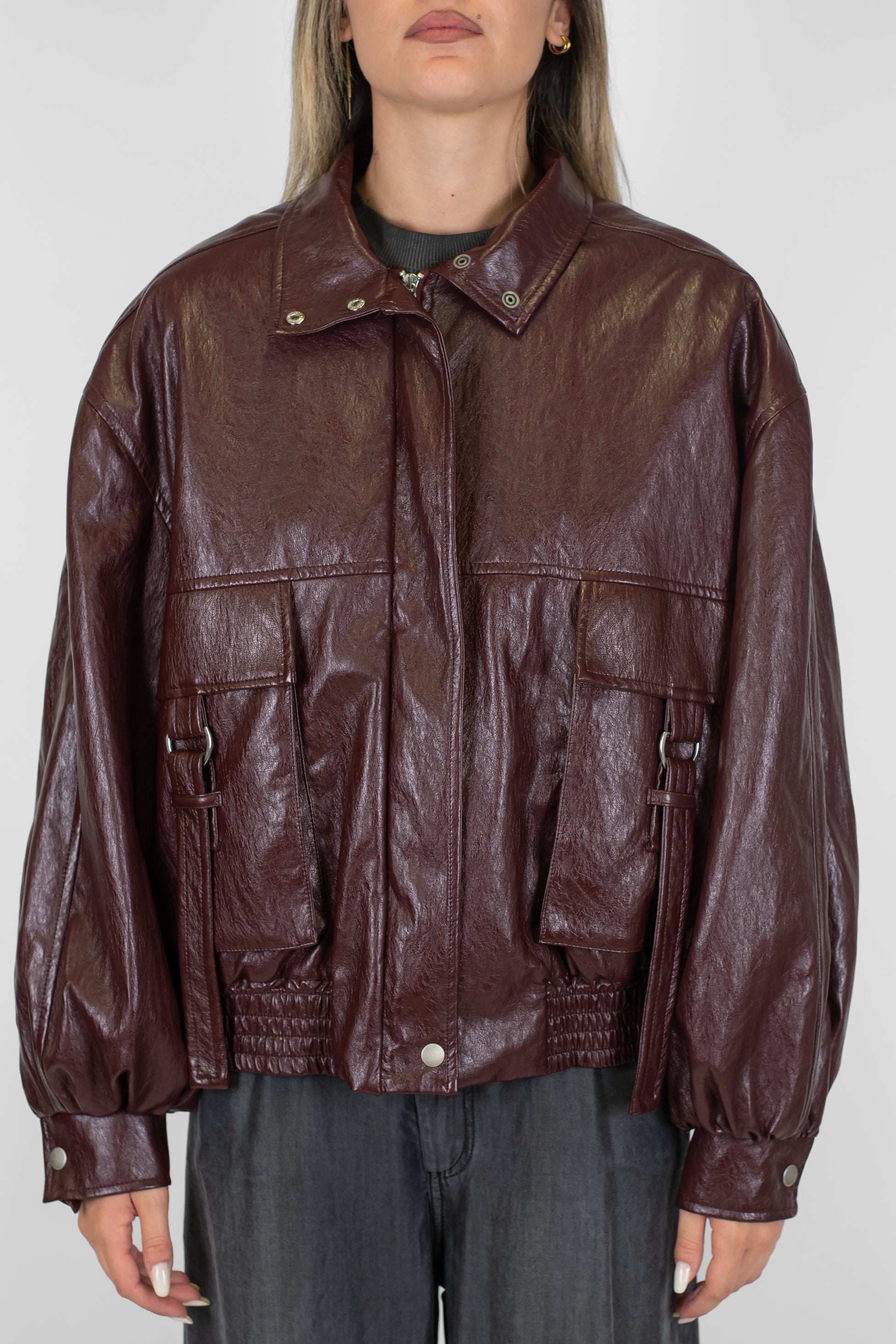 Tensione in - Bomber in ecopelle lucida con tasconi frontali e chiusura zip